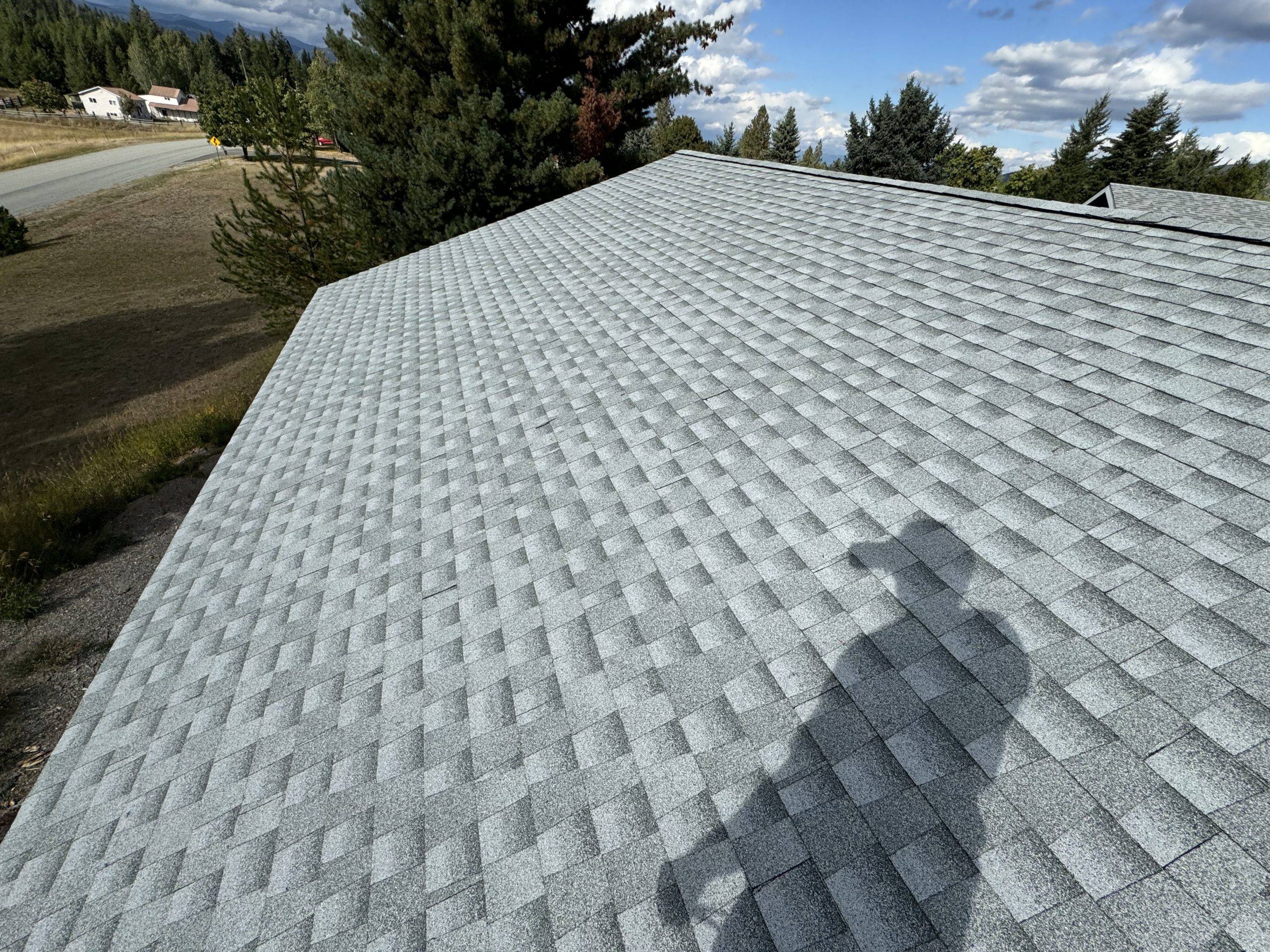 This is a new grey shingled roof in sandpoint idaho with several pitches.